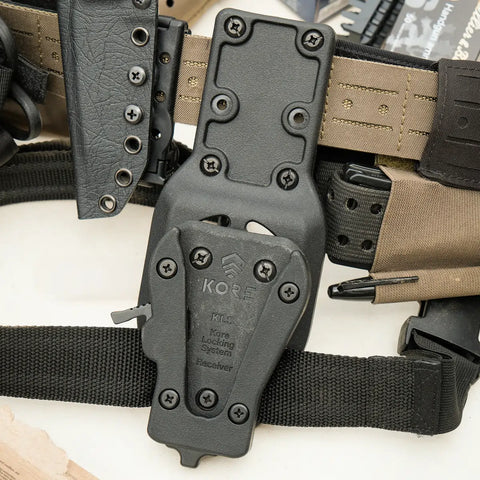 Close-up of a tactical belt with multiple pouches and components on a white background