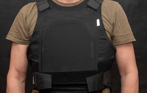 A muscular man wearing a bulletproof vest and a tactical vest.