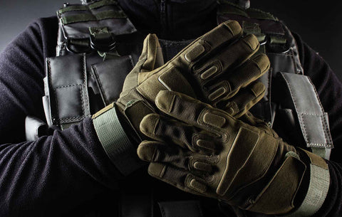 A warrior soldier wearing tactical gloves is standing in a front view closeup.