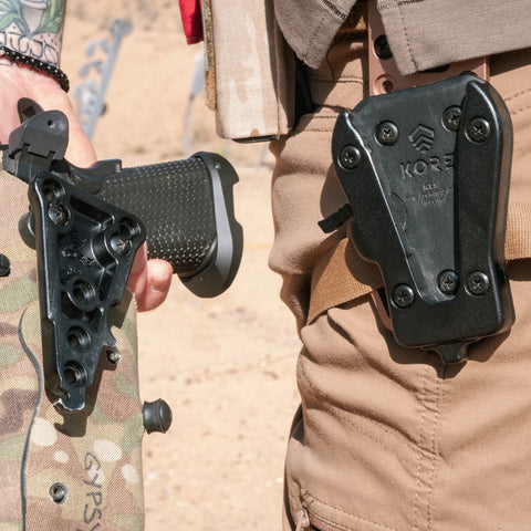 Person holding a bow with a black quiver labeled 'Kore' on a desert background