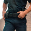 Person wearing a dark uniform with a gun holster on a neutral background